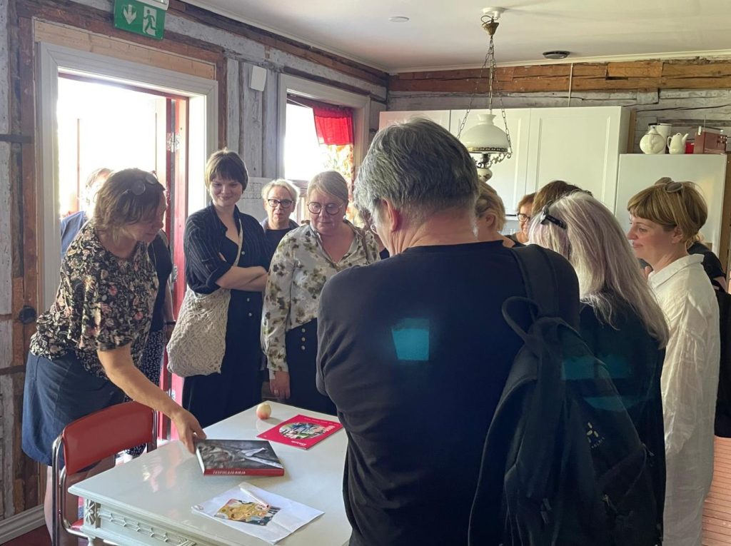 Toimittaja Outi Airola esittelee kirjoittamaansa Yksipihlajan historiikkia emännöimässään Kahvila Sahassa HSJ:n jäsenille.