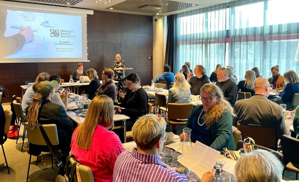 HSJ:n jäsenet ovat kertyneet vuosikokoukseen hotelli Presidentin Sylvi-saliin. Kuvan taka-alalla pitää puhetta Heta Saxell.